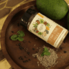 Dhaba Chaat Masala displayed in a bottle, with raw mango, black peppercorns, and cumin seeds arranged around it, showcasing the spice blend and its natural ingredients