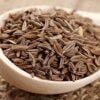 A small bowl filled with aromatic cumin seeds, showcasing their earthy brown color and ridged texture