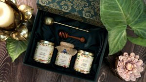 A charming gift box containing three jars, wooden drizzler and Brass Tea Infuser, perfect for hampers and festive gifting ideas.