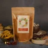 A bag of Rasatva all spice mix powder surrounded by fresh, natural spices on a table, showcasing vibrant flavors and health benefits.